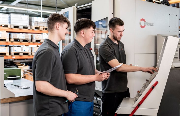 Three trainees operate a machine at Kern Motion Technology