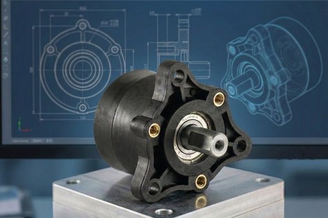 Industriekupplung von Kern Antriebstechnik auf einem Sockel, im Hintergrund technische Konstruktionszeichnung einer Kupplung