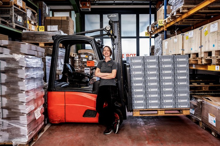 Employee in front of forklift with pallets at Kern Motion Technology